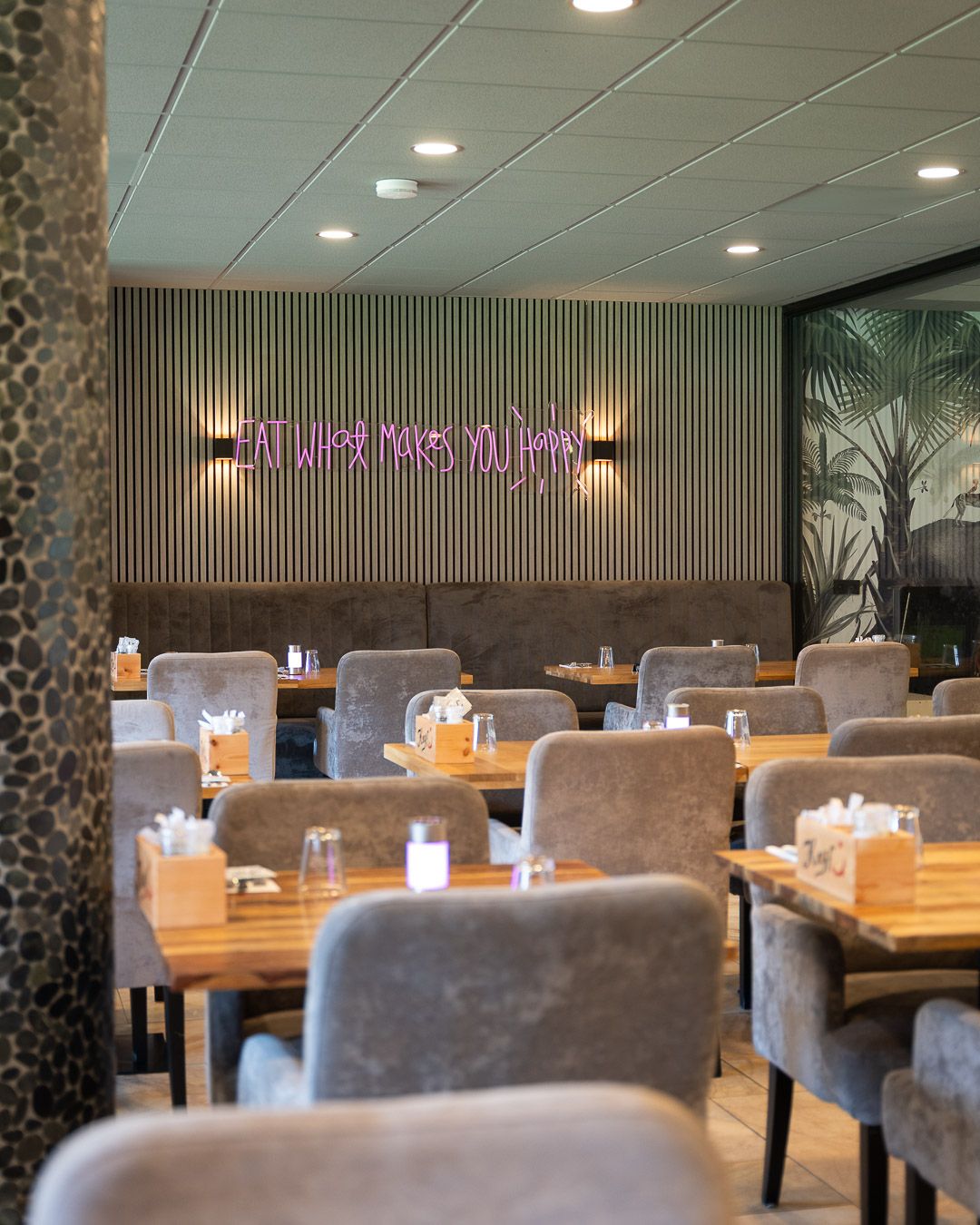 Stijlvol interieur van Keyf Café & Restaurant met warm hout en groene wand